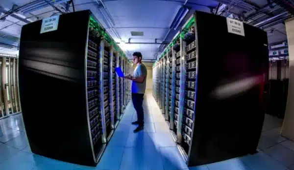 Photo: man standing between data banks